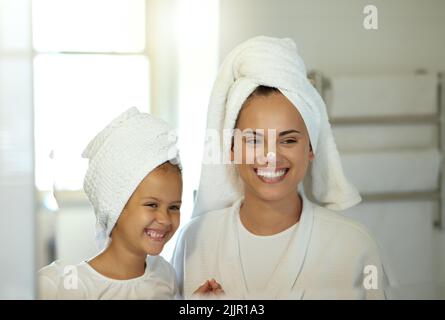 Verspielte Mutter und Tochter, die gemeinsam im Bad eine Hygiene- und Hautpflegeroutine machen. Mutter lehrt ihr entzückendes Kind eine Pflege und Schönheit Stockfoto