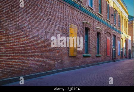 Urban Alley in der Altstadt. Alte Grunge Street. Grungy städtischen Hintergrund einer Backsteinmauer mit Fenstern. Reisefoto, niemand, Platz für Text kopieren Stockfoto