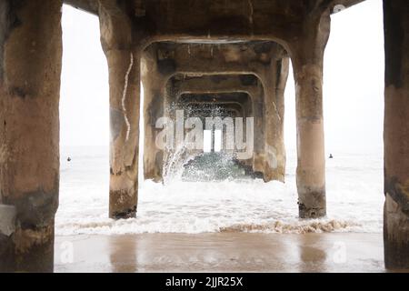 Eine wunderschöne Aussicht auf die Wellen, die unter dem Pier auf das Ufer treffen Stockfoto