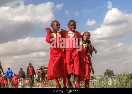 Schüler, die von der Schule durch eine Zuglinie durch das Kibera Slum in Nairobi, Kenia, nach Hause gehen. Leben in Kibera Afrikas größtem Slum. Stockfoto