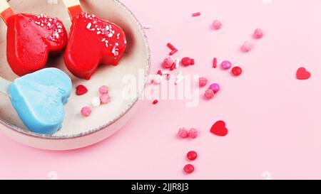 Verschiedene Arten von Eis aus dem Eisbein auf rosa Hintergrund. Stimmungsvolles Sommerkonzept. Draufsicht, flach liegend, Kopierbereich Stockfoto
