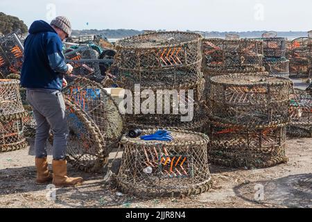 England, Dorset, Christchurch, Mudeford, Fisherman repariert Krabben- und Hummer-Netze Stockfoto