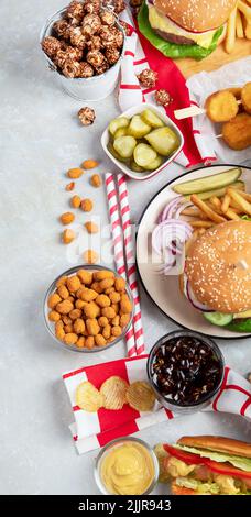 Verschiedene amerikanische Lebensmittel, Pommes frites, Hamburger, Nuggets, Hotdog, Chips, Popcorn, Saucen auf weißem Hintergrund, Draufsicht. Stockfoto