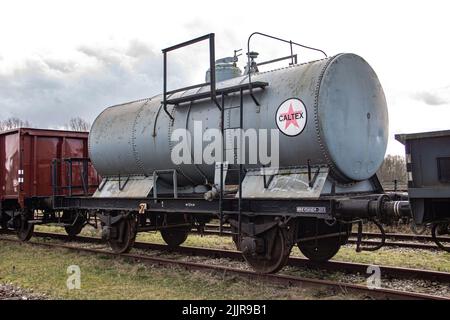 Der Caltex-Zug auf den Schienen in einem alten verlassenen Bahnhof Stockfoto