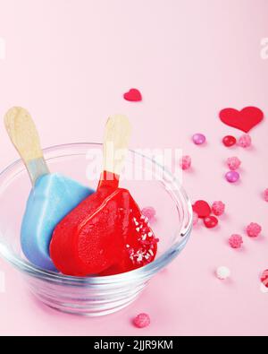 Verschiedene Arten von Eis aus dem Eisbein auf rosa Hintergrund. Stimmungsvolles Sommerkonzept. Stockfoto