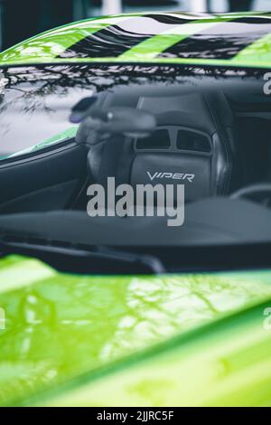 Eine vertikale Aufnahme des Fahrzeuginnenraums, Außenansicht der grünen Dodge Viper SRT 10 durch das Fenster Stockfoto