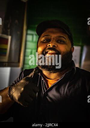 Eine vertikale Aufnahme eines afroamerikanischen Mannes in der Küche eines mexikanischen Restaurants Stockfoto