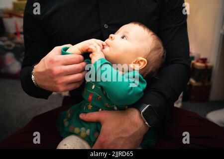 Ein Mann Vater hält ein Baby während der Weihnachtszeit Stockfoto