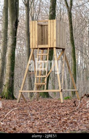 Jagdturm, Holzbaumhaus und Beobachtungsstruktur in einem Wald oder abgelegenen Wald auf dem Land. Holzaussicht für die Beobachtung von Wildtieren gebaut Stockfoto