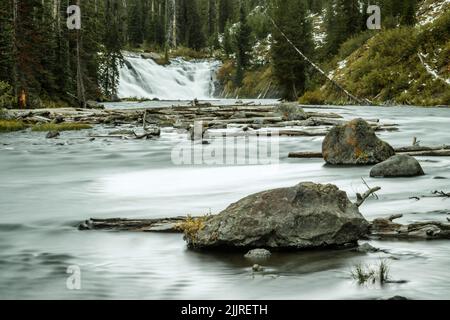 Ein Fernblick auf die langexponierten Lewis Falls im Yellowstone National Park, Wyoming, USA Stockfoto