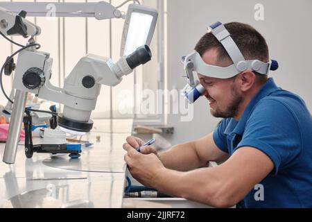 Der Zahntechniker beschäftigt sich mit der Modellierung von künstlichem Zahnersatz. Stockfoto