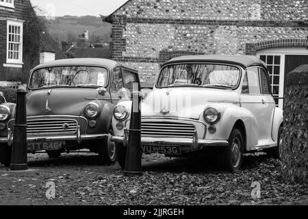 Eine Graustufenaufnahme der alten, ähnlichen Autos, die im Freien geparkt sind Stockfoto