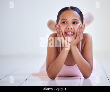 Ballerinas sind so hübsch. Ein kleines Mädchen, das in einem Ballettstudio auf dem Boden liegt. Stockfoto