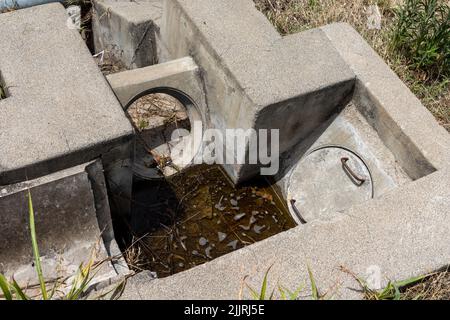Betonentwässerung in Feldern an sonnigen Tag zu keuligen. Stockfoto