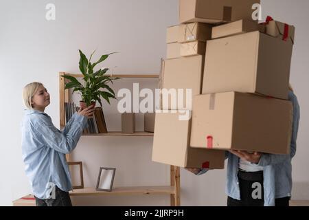 Junges Paar Umzug in ein neues Haus, Umzug Tag, neue Wohnung, Mietwohnungen, Mann und Frau bringen große Kartons ins Haus, Umzug und Stockfoto