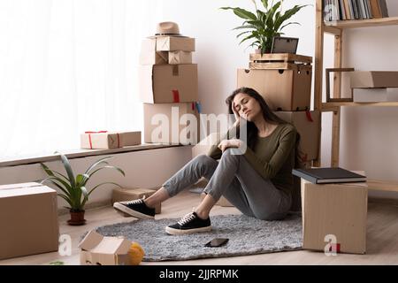 Junge müde Mädchen Gefühl Müdigkeit am harten Umzug aus Tag, schlafende Frau mit Haufen von beweglichen Boxen sitzen auf im Stock Haus Stockfoto