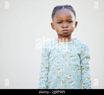 Mama sagte, dass ich dieses Jahr auf der unartigen Liste stehen sollte. Ein entzückendes kleines Mädchen, das vor einem weißen Hintergrund steht. Stockfoto