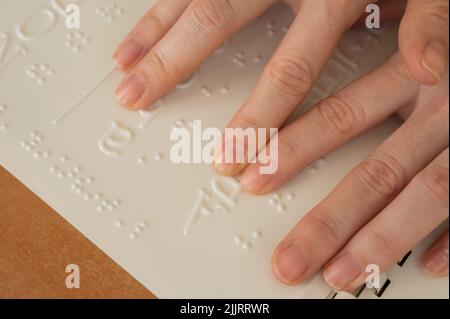 Eine Frau lernt das Braillealphabet mit einem Decoder. Stockfoto