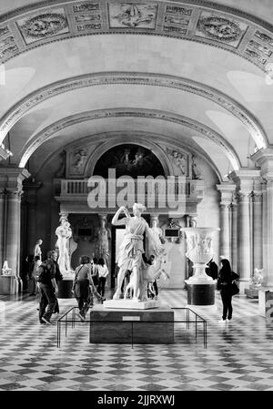 Eine Vertikale aus Skulpturen im Louvre in Paris, Frankreich, in Graustufen gedreht Stockfoto