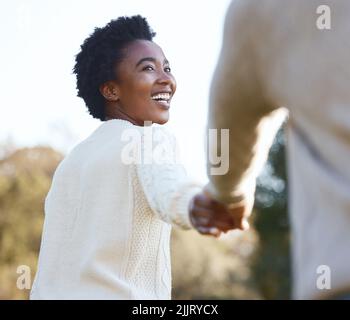 Lassen Sie mich den Weg gehen: Eine junge Frau, die die Hand ihres Mannes hält. Stockfoto