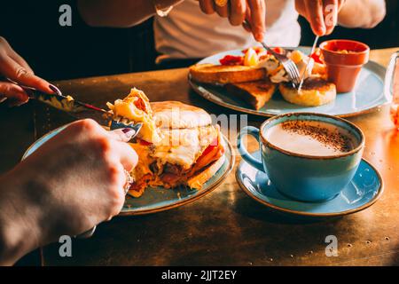 Das gesichtslose Paar, das in einem Restaurant mit Kaffee zu Mittag gegessen hat Stockfoto