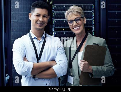 Erwarten Sie keine Wartezeit bei uns. Zwei Techniker arbeiten zusammen in einem Serverraum. Stockfoto