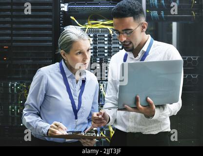 Zwei Techniker arbeiten zusammen in einem Serverraum. Stockfoto