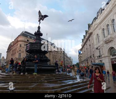 London, Greater London, England, 30 2022. Juni: Menschenmassen um den Shaftesbury Memorial Brunnen aka Eros nach dem Regen im Piccadilly Circus. Stockfoto