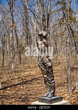 Eine vertikale Aufnahme einer Bronzestatue einer Frau im Overland Park Arboretum, Kansas, USA Stockfoto