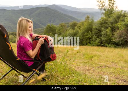 Müde Frau im mittleren Alter, die sich nach dem Wandern in der Natur ausruhte Stockfoto