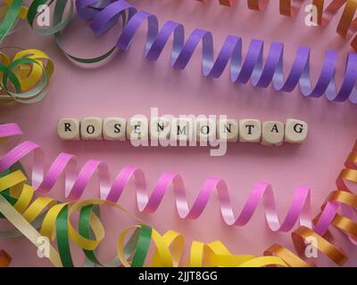 Rosenmontag in Holzwürfeln auf rosa Hintergrund Stockfoto
