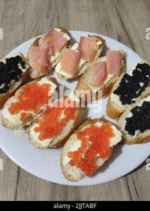 Ein Sandwich mit rotem und schwarzem Kaviar auf einem Teller Stockfoto