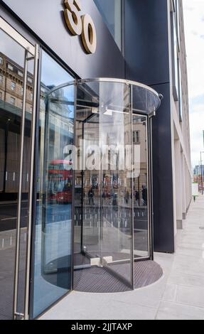 Drehtür aus Glas mit Reflexionen, 50 Eastbourne Terrace, neues Geschäftsgebäude mit gemischter Nutzung gegenüber der Paddington Station, London, Großbritannien. Stockfoto