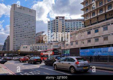 Edgware Road, Paddington mit Autos und London Doppeldeckerbus. Overpass, Hilton Hotel und andere hohe Gebäude im Hintergrund. Stockfoto