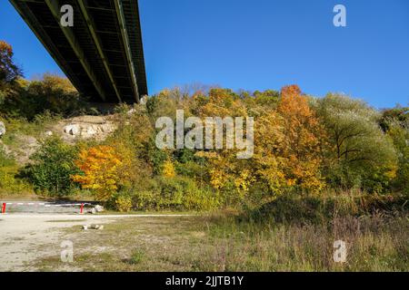 Ein kleiner See, umgeben von Bäumen unter einer Brücke Stockfoto