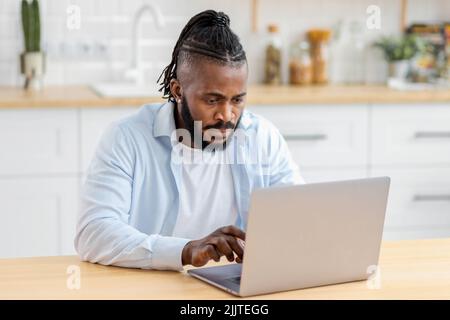 Porträt eines fokussierten afroamerikanischen Freiberuflers, der per Computer Remote-Zugriff online zu Hause arbeitet Stockfoto