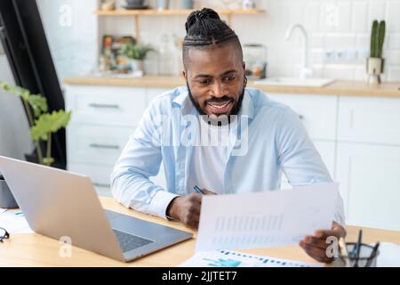 Selbstbewusster Geschäftsmann, Freiberufler, der die Jahresumsatztabelle analysiert Mann, der von zu Hause aus arbeitet Stockfoto