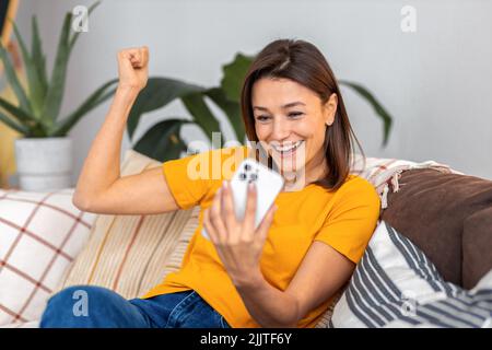Porträt einer fröhlichen jungen Frau mit Mobiltelefon Stockfoto