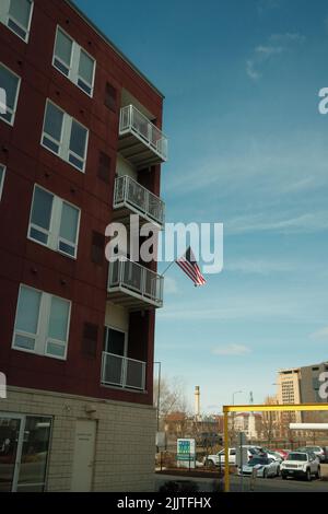 Eine Aufnahme eines roten Gebäudes mit einer amerikanischen Flagge vor einem blauen Himmel in Saint Paul, Minnesota Stockfoto