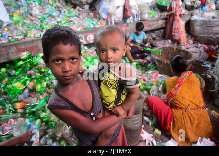 Kinderarbeiter sortieren am 27. Juli 2022 in einer Recyclingfabrik in Dhaka, Bangladesch, Polyethylenterephthalat (PET)-Flaschen. Recycling von Kunststoff Stockfoto