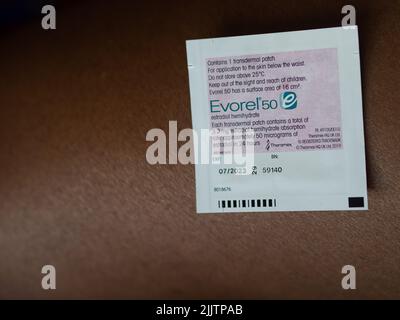 Evorel HRT Patch wird auf die Haut einer farbigen Frau gelegt Stockfoto
