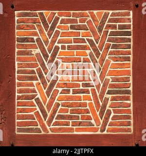 Alte rote Backsteinmauer mit Holzbalken als Textur oder Hintergrund. Architektonische Details. Stockfoto