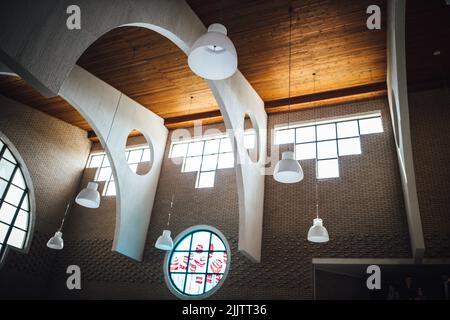 Eine Innenansicht einer Kirche mit modernem Design und schönen weißen Lampen, die an einer Holzdecke hängen Stockfoto