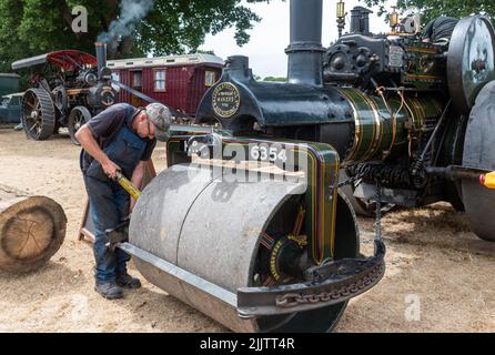 New Forest und Hampshire County Show im Juli 2022, England, Großbritannien. Mann, der an einer alten Wallis & Steevens Dampfwalze arbeitet. Stockfoto
