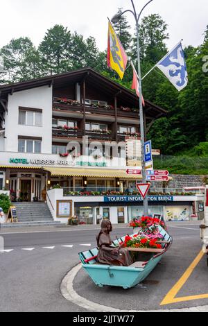 Eine vertikale Aufnahme eines dekorativen Bootes mit Blumen und einem typischen Häuschen in Interlaken, Schweiz. Stockfoto