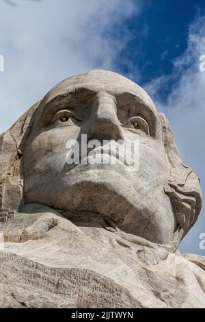 Eine vertikale Aufnahme eines George Washington, des ersten Präsidenten der Vereinigten Staaten, der in die Seite des Mount Rushmore geschnitzt wurde Stockfoto