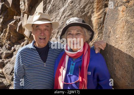 Maurice Lee (86) und seine Frau Wilma Lee (83), gebürtiger Australier, aus China, tourten durch den Sacred Canyon in den Flinders Ranges in Südaustralien. Sowohl Maurice als auch Wilma aktive Senioren gaben erst vor ein paar Jahren das Skifahren auf. Jetzt reisen sie, um ihre Liste der Orte zu füllen, die sie schon immer in Australien besuchen wollten. Sie sind dabei, ihren Hochzeitstag 62. zu feiern. Das Foto zeigt Maurice und Wilma, mit einer der Aborigines-Perraglyphen im Sacred Canyon, die in der Nähe von Wilpena Pound liegt. Stockfoto