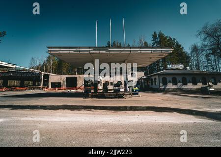 Eine verlassene und verbrannte Tankstelle in Finnland, die an einem sonnigen Frühlingstag gefangen genommen wurde Stockfoto