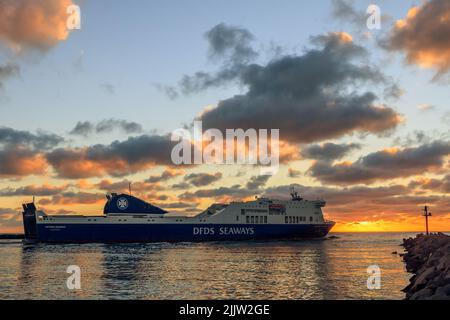 Ein farbenfroher Sonnenuntergang vor den Toren des Hafens von Klaipeda. Litauen während DFDS Seaways Fracht-Passagierfähre, die den Hafen verlässt Stockfoto