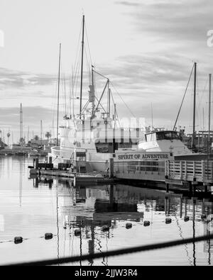 Eine Graustufenaufnahme eines großen Fischerbootes, das auf dem Wasser im Hafen von Ilwaco in den Vereinigten Staaten reflektiert wird Stockfoto